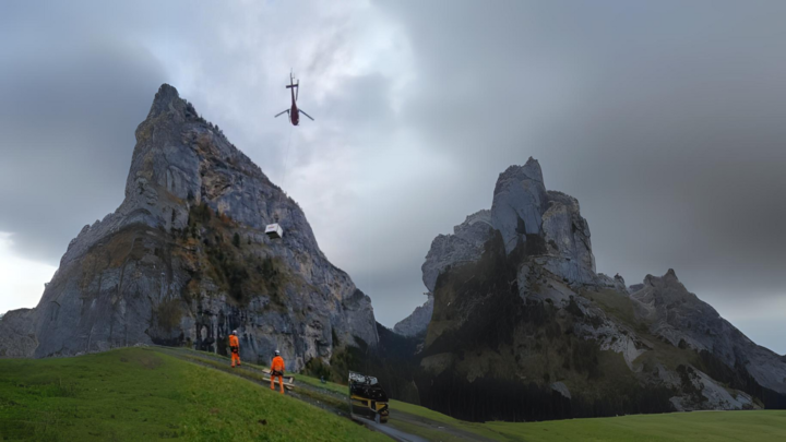 Eine flugfähige Inspektionsanlage am Helikopter vor einem Bergpanorama